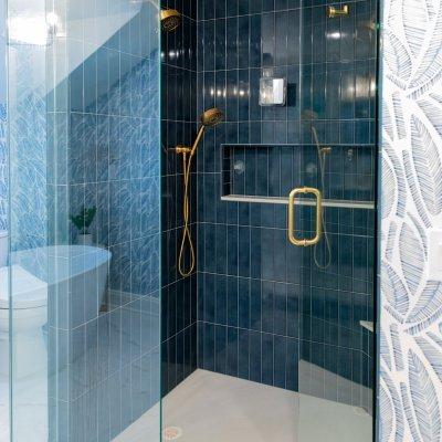 套房附加玻璃门淋浴间，蓝色瓷砖墙壁和金色固定装置